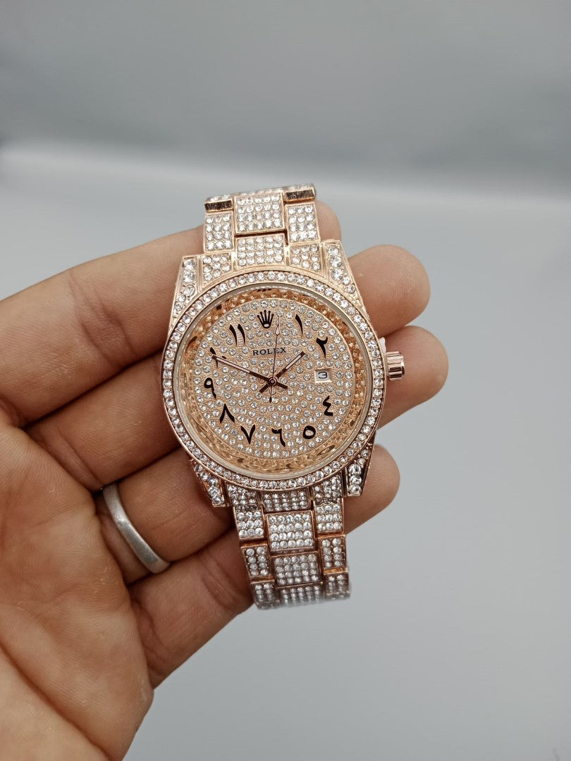 Rose gold watch with diamond accents held in a hand against a neutral background