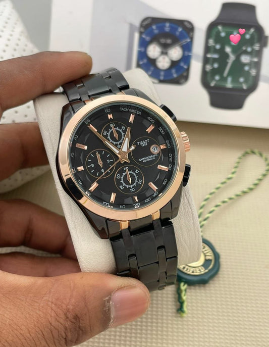 Black and rose gold watch held by a hand with blurred watches in the background