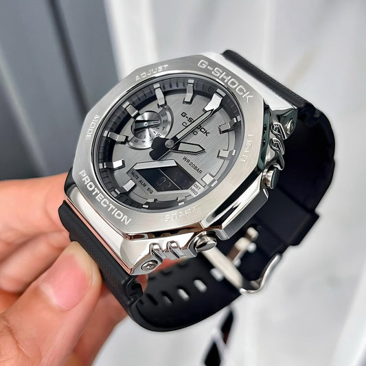 G-Shock watch with black strap held by a hand against a light background