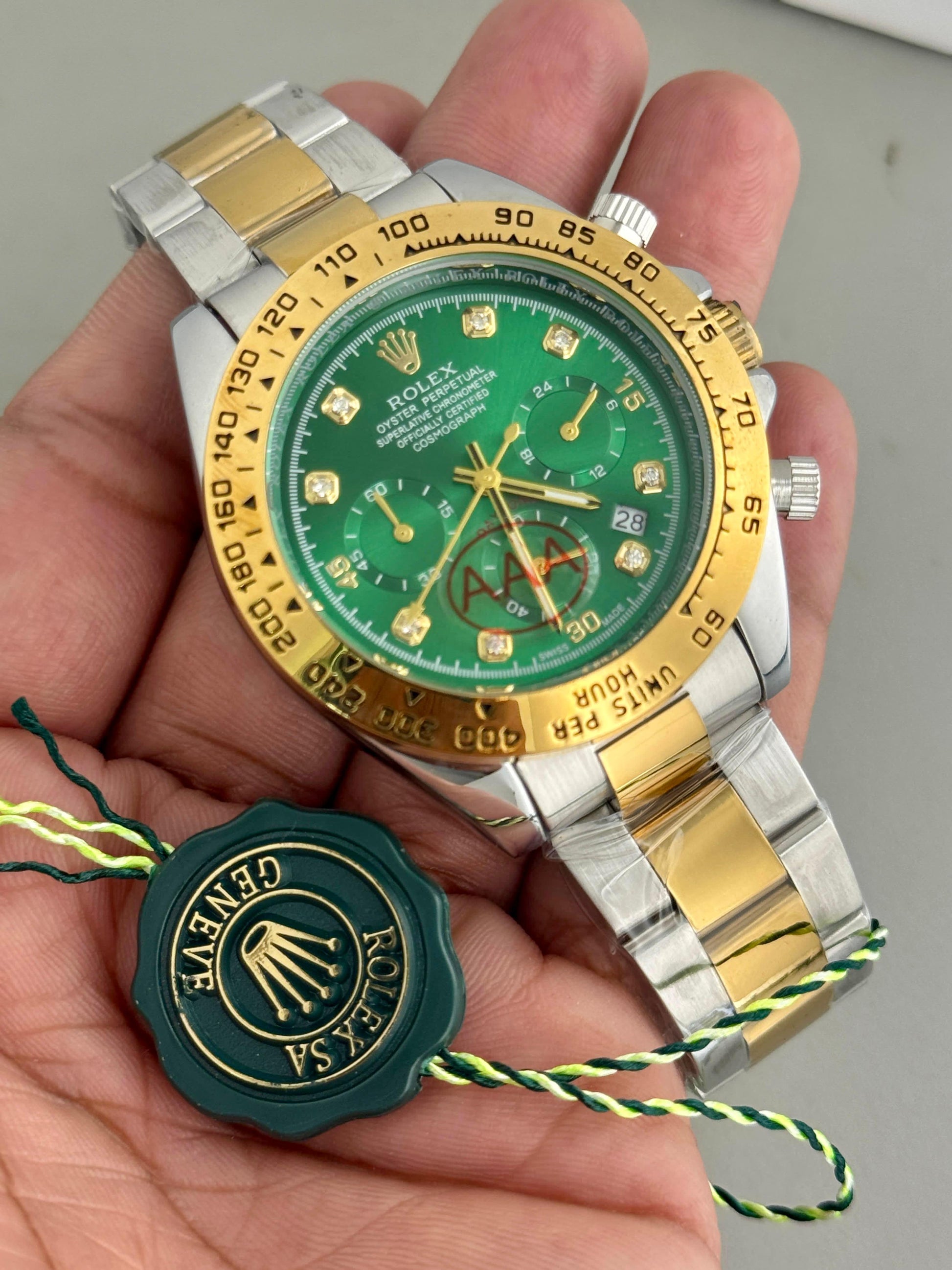 Rolex watch with green face and gold accents held in a hand
